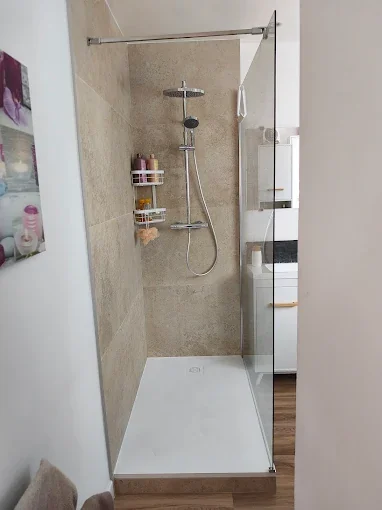 Rénovation salle de bain moderne avec douche à l'italienne en travertin à Valenciennes — JL Énergies